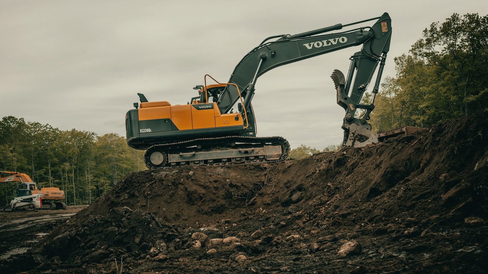 An excavator working at the top of a dirt slope